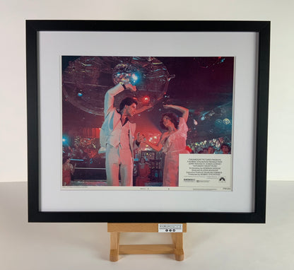 An original and framed 11x14 lobby card for the film Saturday Night Fever