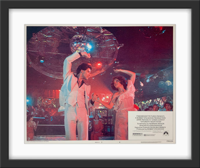 An original and framed 11x14 lobby card for the film Saturday Night Fever